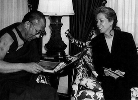 Screenwriter Melissa Mathison shows the Dalai Lama photographs from the set of Kundun. Courtesy John Bigelow Taylor/Melissa Mathison.