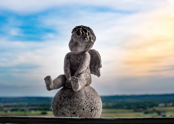 baby angel statue against colorful sky for story on taking refuge