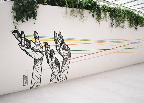 photograph of a mural of hands with interconnecting strings coming from fingertips for story on relationship growth