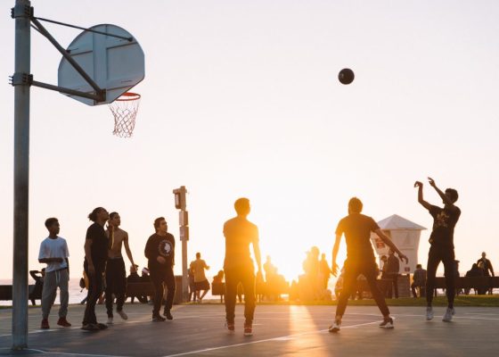people playing basketball while the sun sets behind them for story on spirit in sport