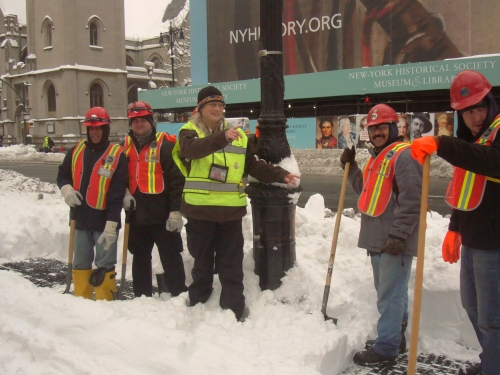 Jeana poses with city workers shoveling snow