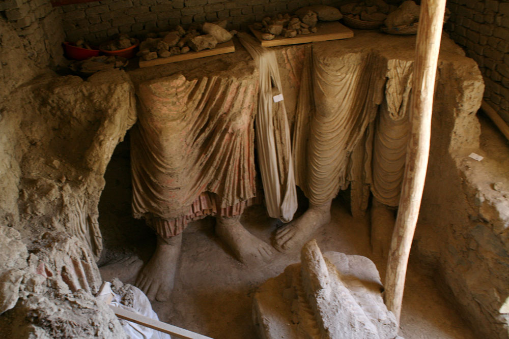 Feet of Buddhist statues found in the central room of the monastery