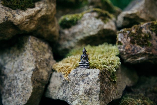 small buddha on a big rock
