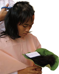 During her ordination as a Theravada nun at Thailand’s Songdhammakalyani monastery, Jiep collects her hair in a lotus leaf.