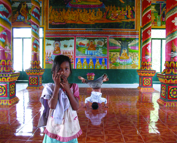 Wat Opot children playing before newly restored murals of the life of the Buddha at Wat Opot Pagoda.