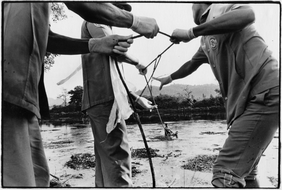 Image 2: Rescue volunteers retrieve a corpse from a lake near the town of Khao Lak in southern Thailand.