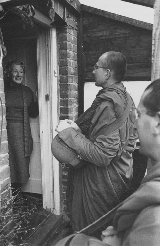 A resident of West Sussex receiving the Chithurst monks on their alms-round. Courtesy of the Chithurst Buddhist Monastery.