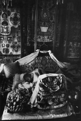 Martine Franck, Kalu Rinpoche's new reincarnation asleep on his throne, surrounded by offerings for the Tibetan New Year, Sonada monastery, near Darjeeling, India, 1993.