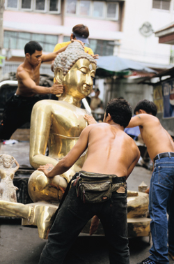 Men in Bangkok, Thailand move a new Buddha statue onto a truck © Alison Wright