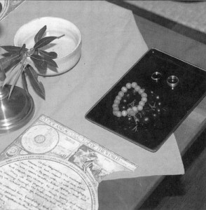 Image 2: The marriage altar is prepared with rings, malas, water, candle, and vows.