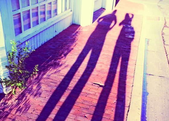long shadows of two people on a sidewalk for article about long-term meditation practices