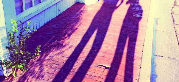 long shadows of two people on a sidewalk for article about long-term meditation practices