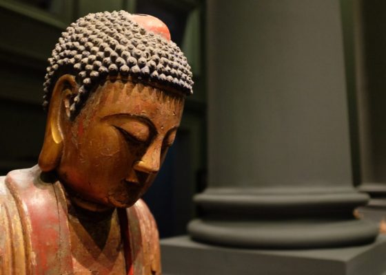 image of a buddha's head with a column in the background