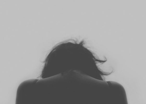 image of a female head from behind, bent over; buddhism and chronic pain