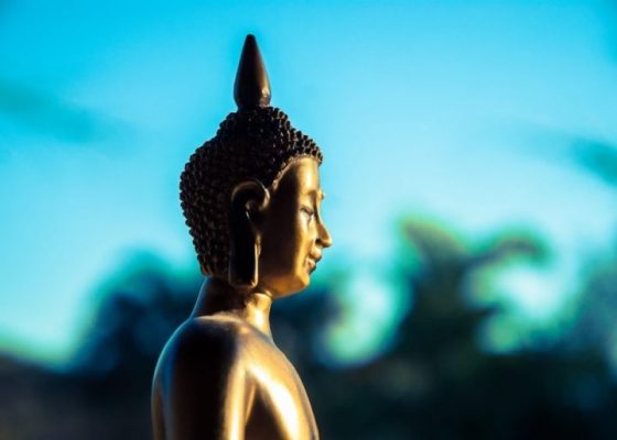 buddha statue against a blue sky background for story on spiritual teachers and mental health