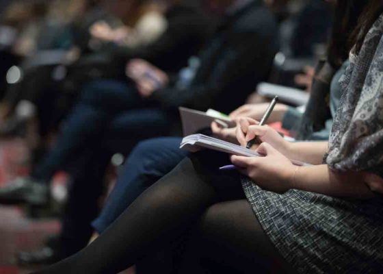 image of a person in a lecture hall taking notes, international mindfulness teachers association