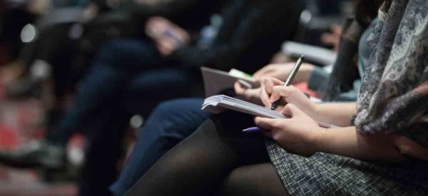 image of a person in a lecture hall taking notes, international mindfulness teachers association