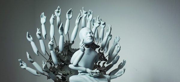 Grey and metallic sculpture of a robot in a meditation posture with many mechanical arms surrounding its body, artificial intelligence buddhism