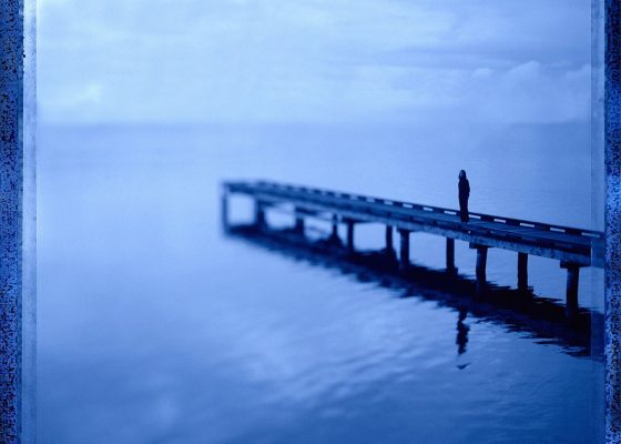 Man standing on pier, silent meditation retreat