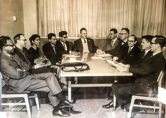University scholars sitting around table with Richard Robinson
