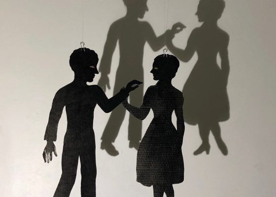 Shadow puppet of a man reaching out to touch a woman, depicting sexual abuse in Buddhism