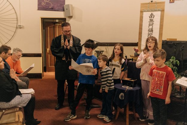 Aaron Proffitt leads a prayer with the children of the Albany Pure Land Buddhist sangha.