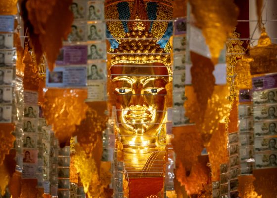 A large golden buddha statue surrounded by other decorations in Chiang Mai, Thailand