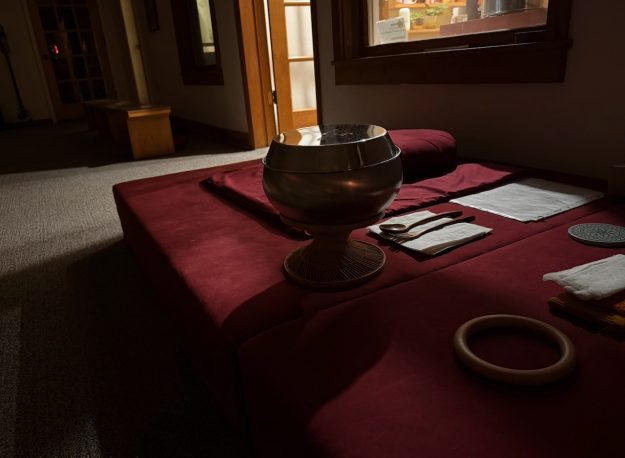 A monk's bowl gleams in morning light from the sangha hall before the day’s first meditation